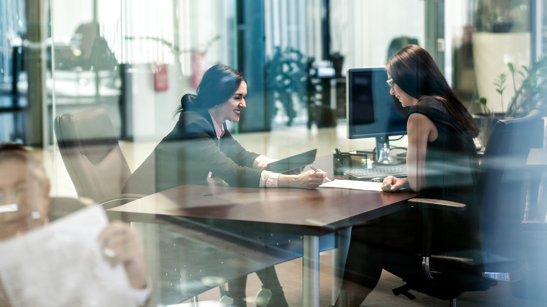 An image of a small business consultant meeting with an owner managed business to discuss future business restructuring
